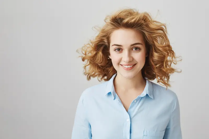 cheerful-smiling-curly-haired-female-employee-looking-confident cheerful-smiling-curly-haired-female-employee-looking-confident